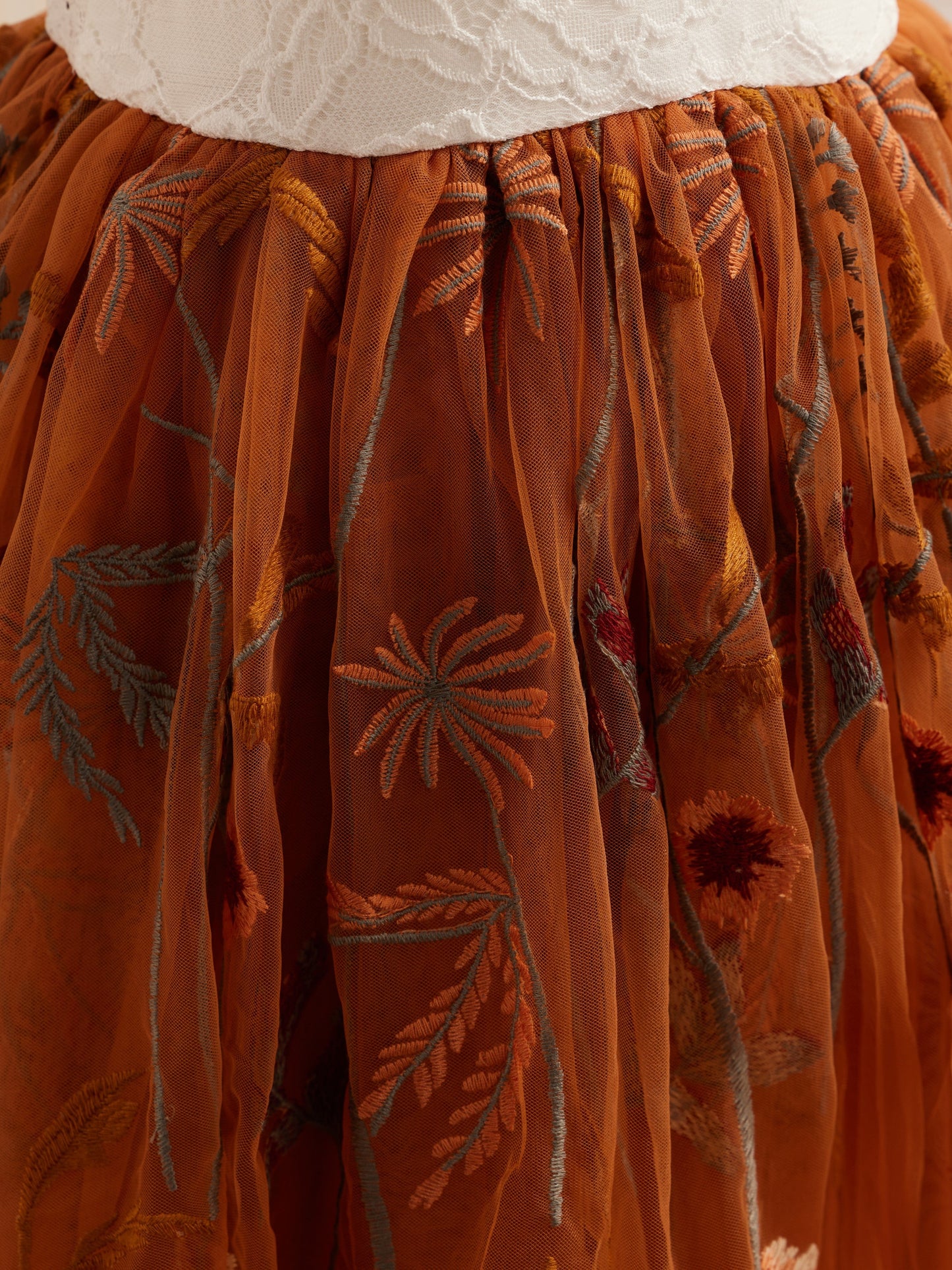 Knielanges Blumenmädchenkleid aus gebranntem Orange und weißer Spitze mit Tüllstickerei