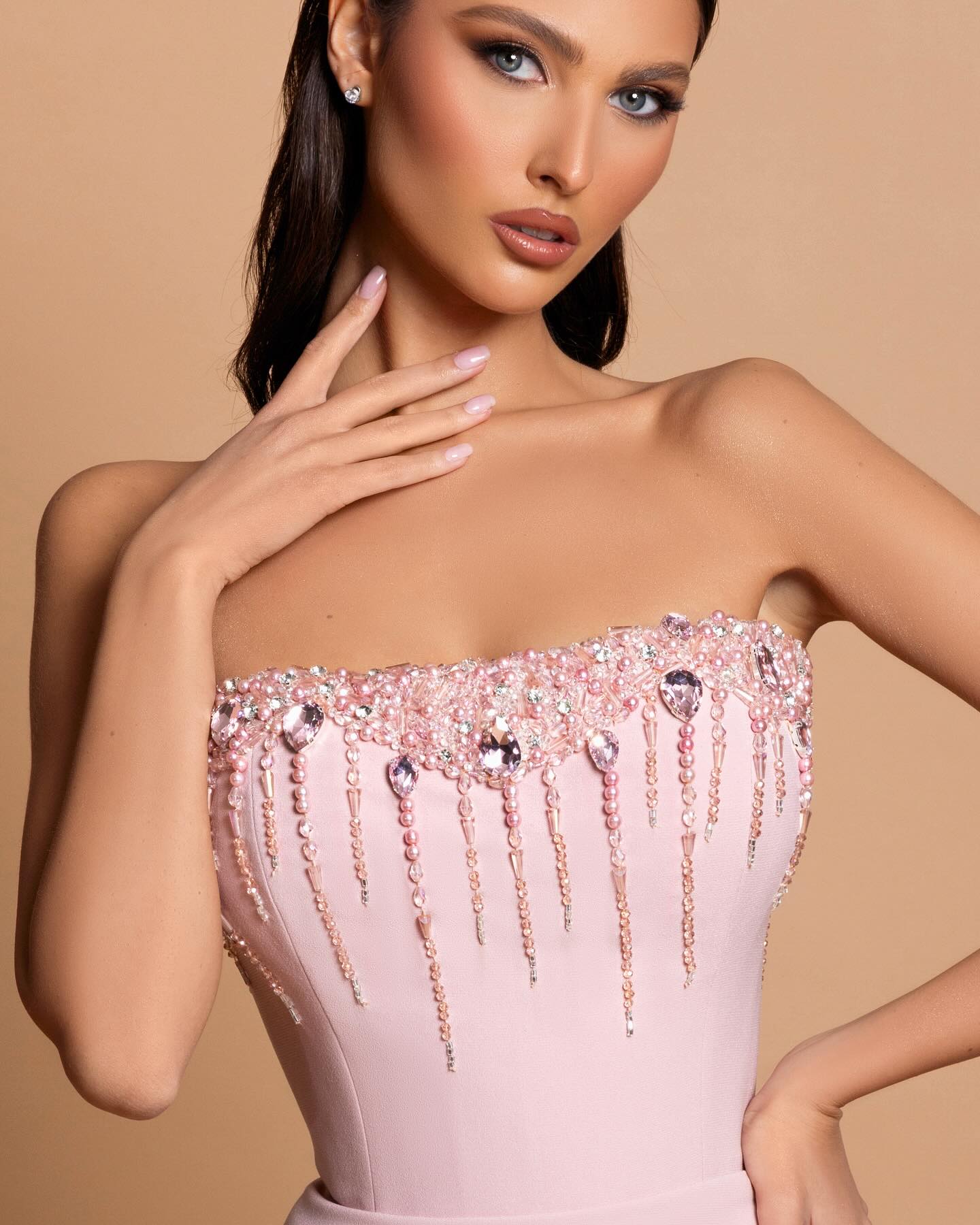 Impresionante vestido de fiesta rosa con escote en V, sin tirantes, sin mangas, de satén con pedrería y espalda abierta y cola.