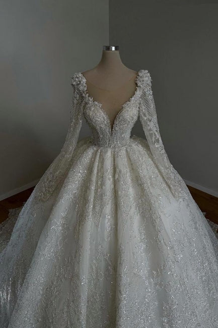 Impresionante vestido de novia largo estilo princesa, corte A, escote en V, encaje, cuentas y mangas largas.