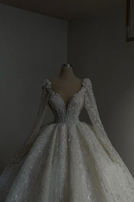 Impresionante vestido de novia largo estilo princesa, corte A, escote en V, encaje, cuentas y mangas largas.