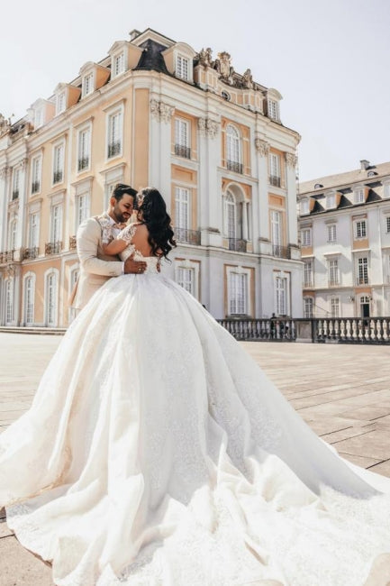 Vestido de novia de tul con escote corazón, mangas largas, apliques y cuentas, largo hasta el suelo.