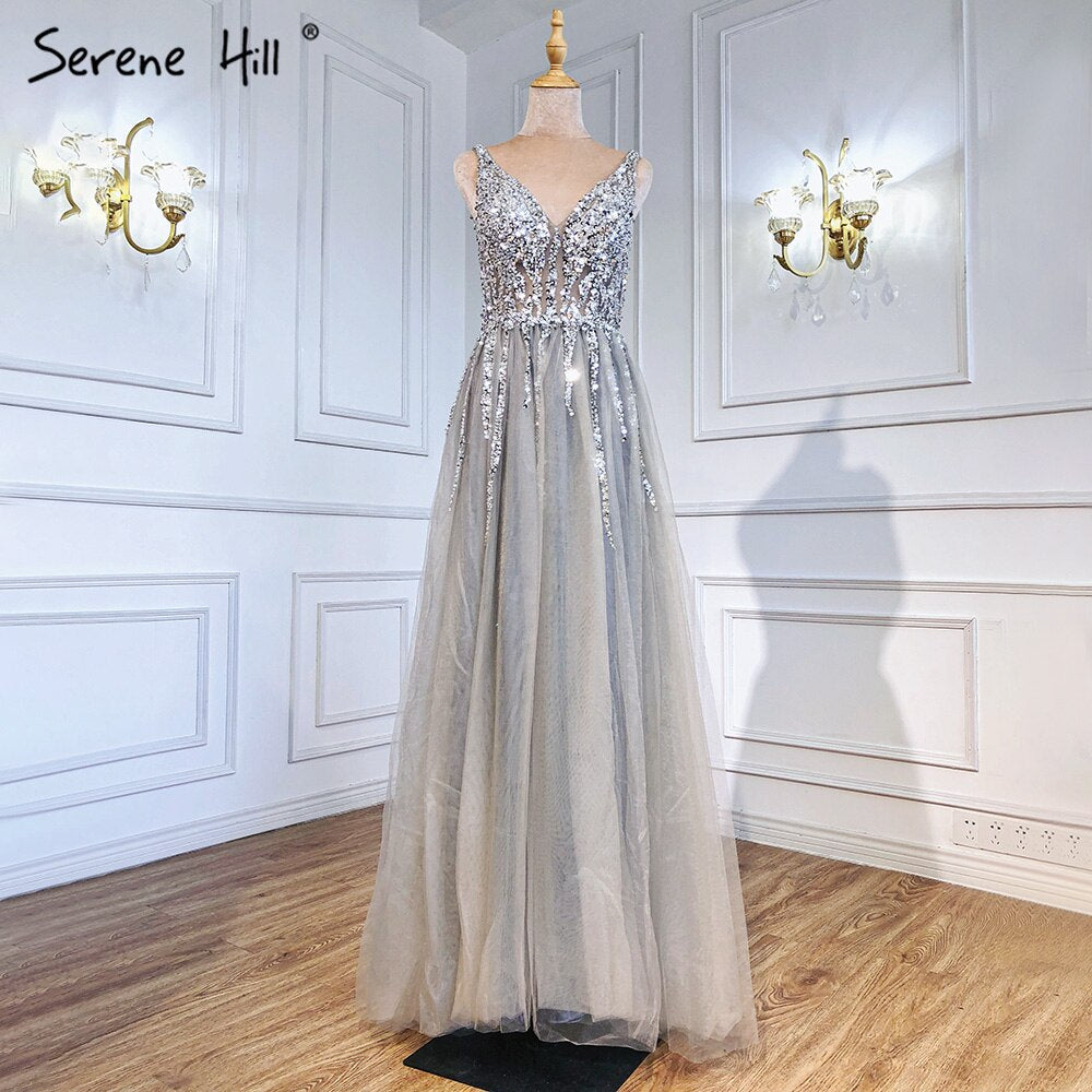 En oferta, sin devolución ni reembolso.Vestido de noche gris sin espalda, corte A, escote en V, sin mangas, con pedrería y diamantes. Diseño de vestido de noche sexy 2025 LA70168.