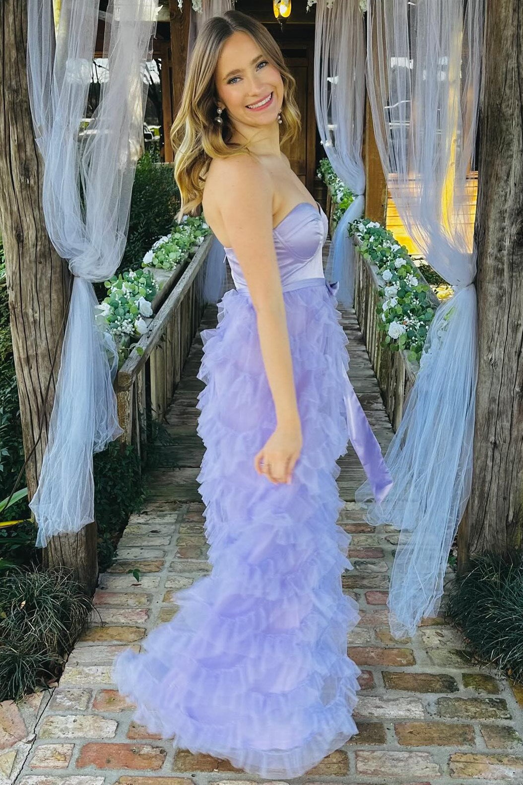 Vestido largo lavanda con volantes, cinturón y lazo en forma de corazón
