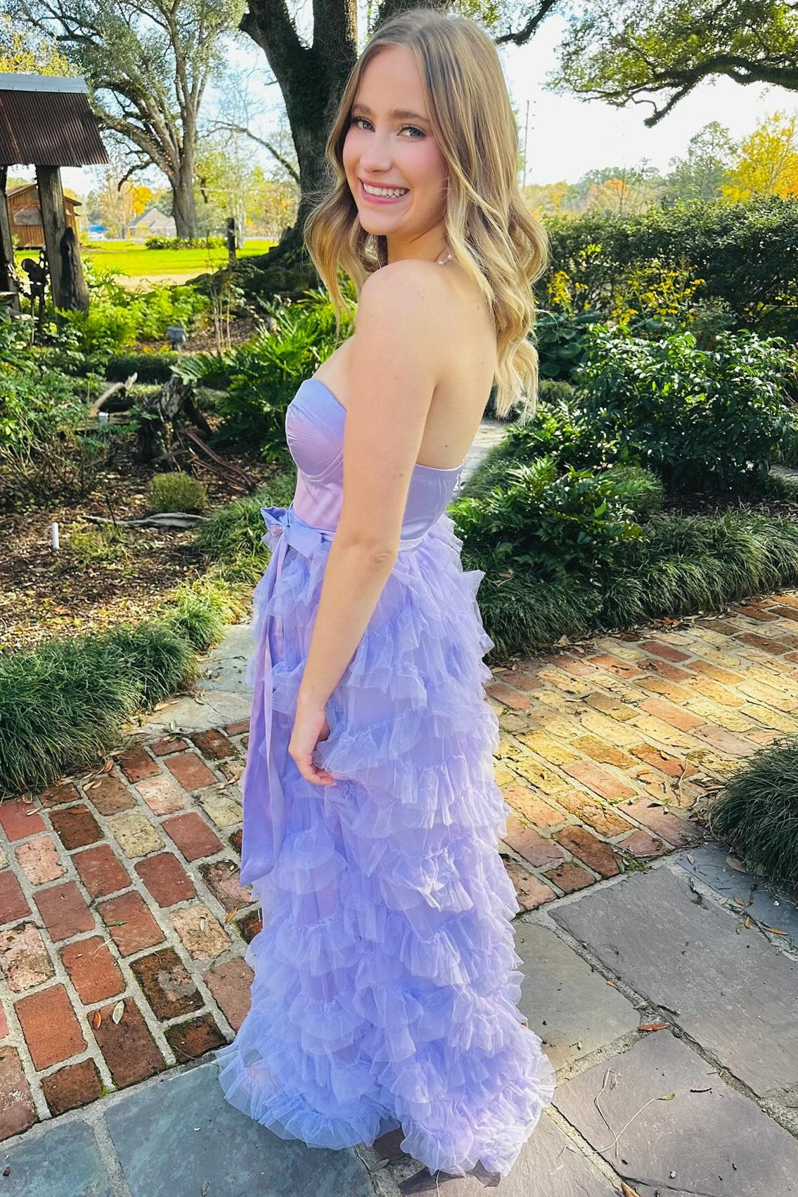 Vestido largo lavanda con volantes, cinturón y lazo en forma de corazón
