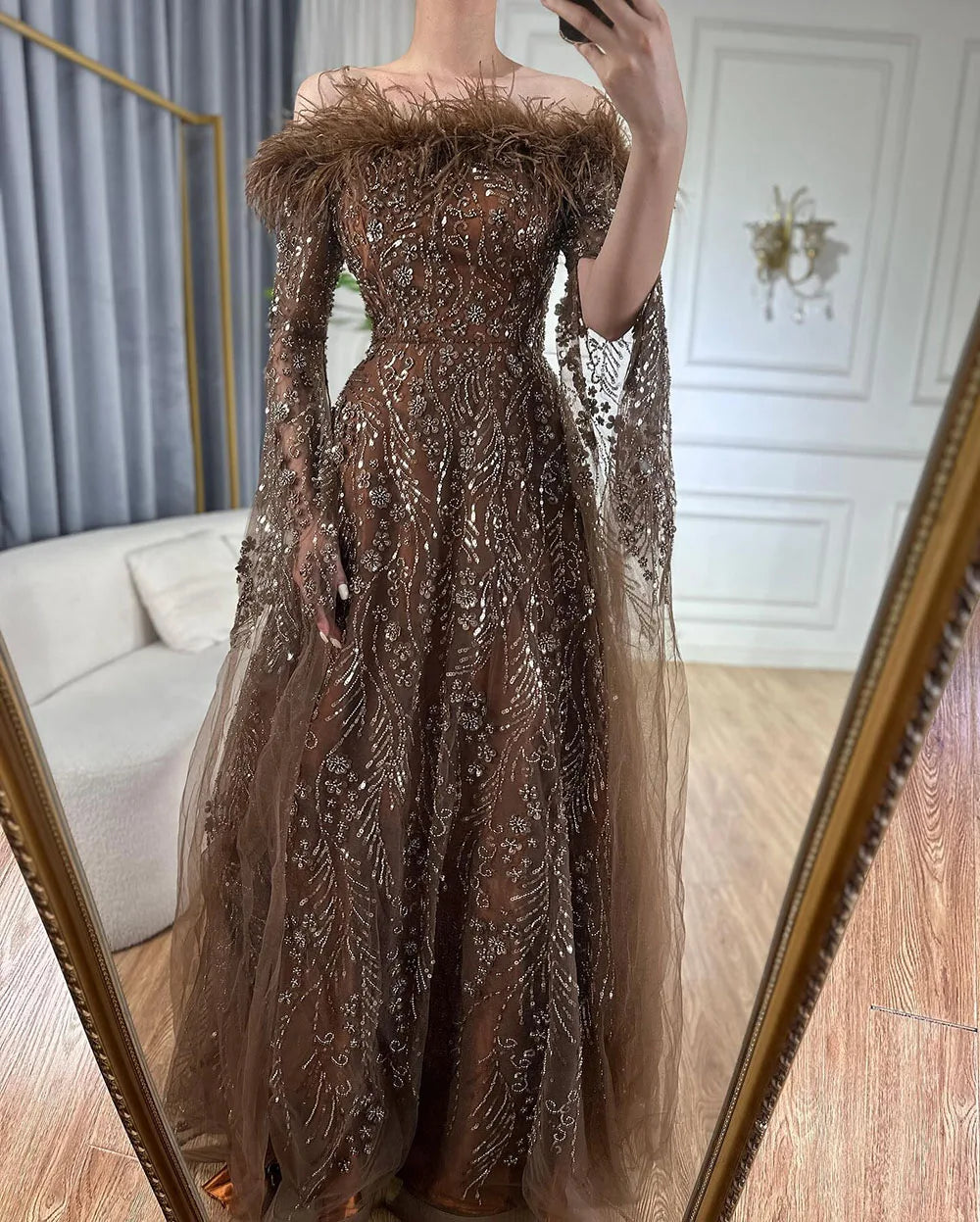 Vestido de noche marrón con plumas y hombros descubiertos y mangas estilo capa LA72401