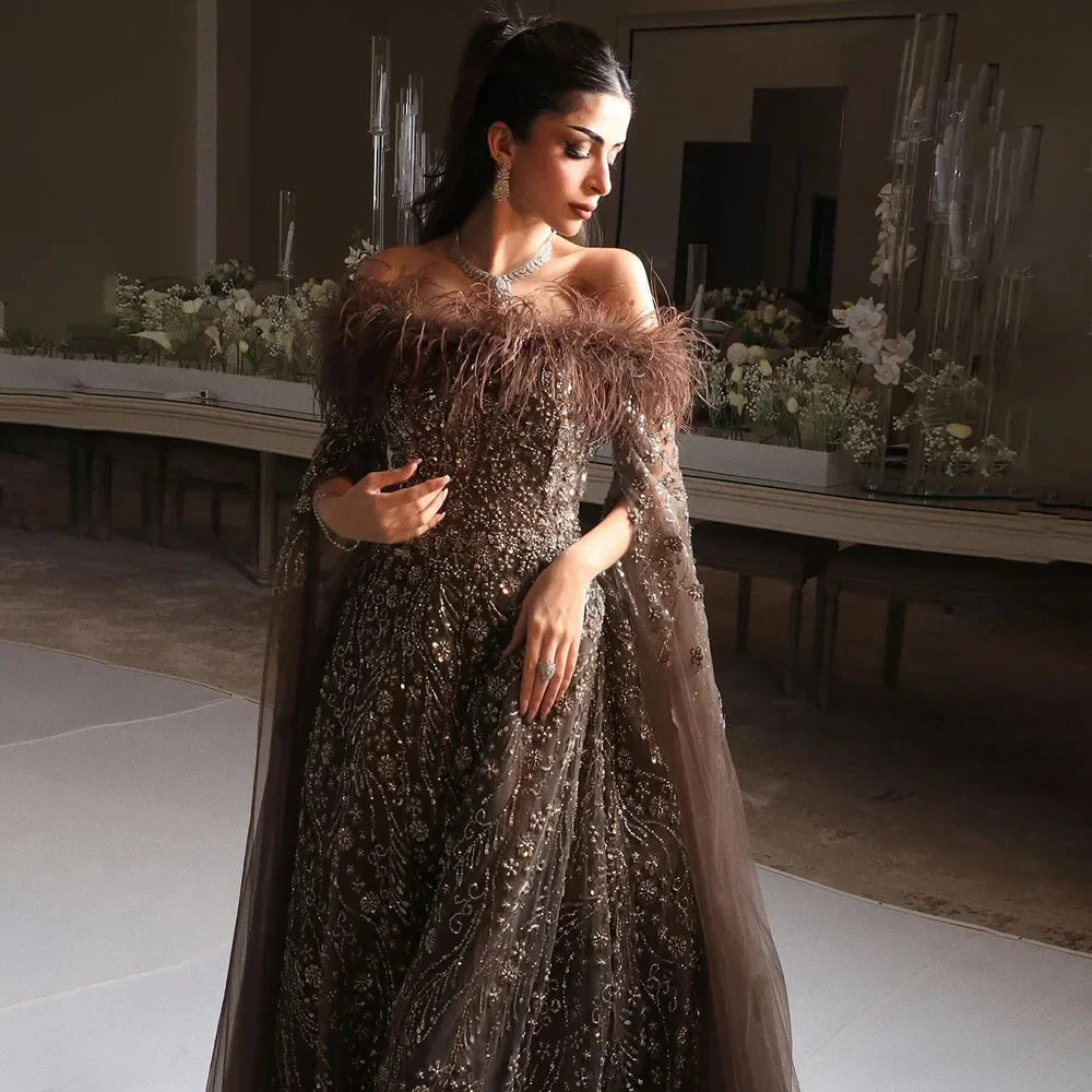 Vestido de noche marrón con plumas y hombros descubiertos y mangas estilo capa LA72401
