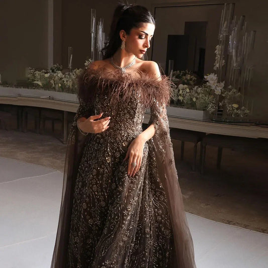 Vestido de noche marrón con plumas y hombros descubiertos y mangas estilo capa LA72401
