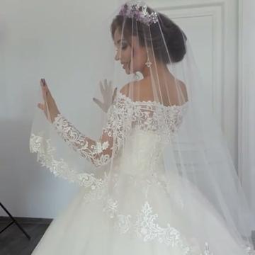 Hermoso vestido de novia estilo princesa con apliques de encaje y mangas largas y hombros descubiertos