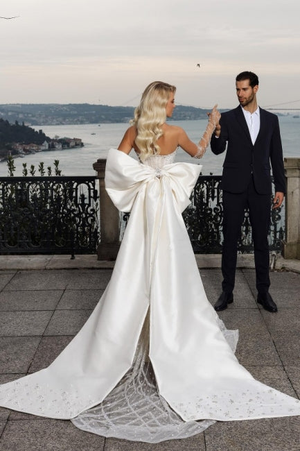Hermoso vestido de novia de sirena sin tirantes y escote corazón con cola capilla