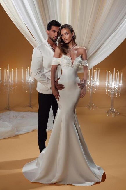 Encantador vestido de novia color marfil sin mangas, con hombros descubiertos y escote en forma de columna y cuentas.