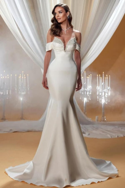 Encantador vestido de novia color marfil sin mangas, con hombros descubiertos y escote en forma de columna y cuentas.