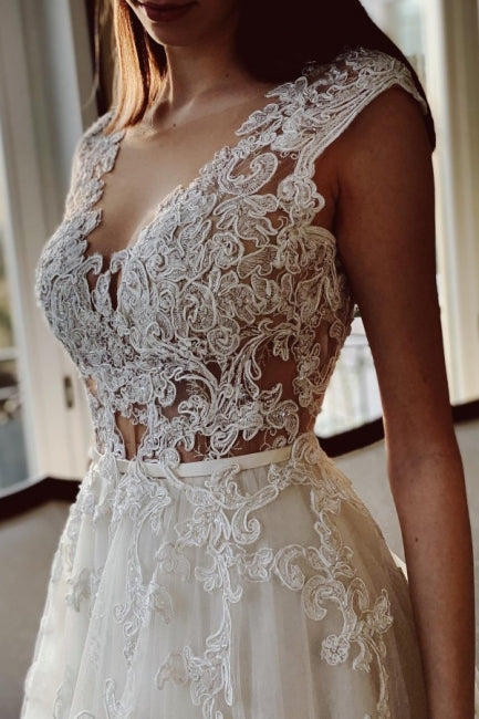Vestido de novia de encaje color marfil, corte A, largo hasta el suelo, escote en V y jardín.