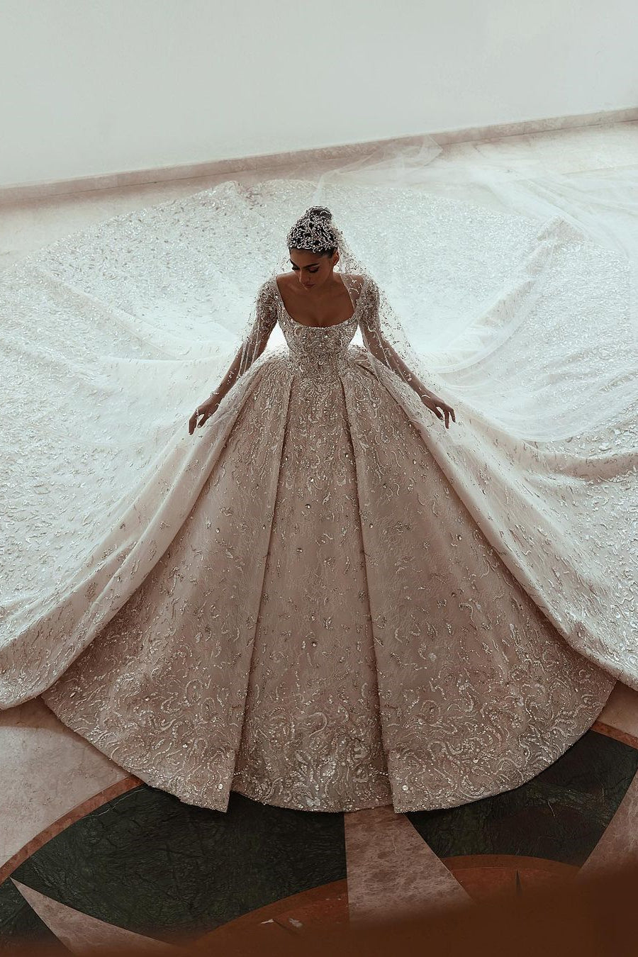 Lujoso vestido de novia de encaje con cola y mangas largas en forma de A