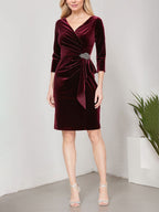 Vestido corto de terciopelo con escote cruzado, falda en cascada y detalle de adorno en la cadera.