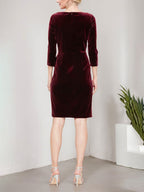 Vestido corto de terciopelo con escote cruzado, falda en cascada y detalle de adorno en la cadera.