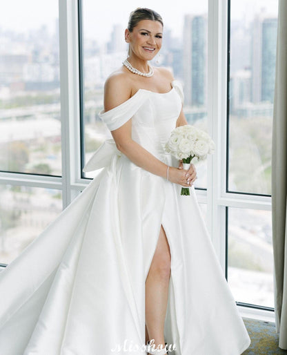 Hermosos vestidos de novia blancos de corte A, hombros descubiertos, escote redondo, sin mangas, volantes, satén y abertura frontal.