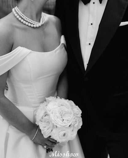 Hermosos vestidos de novia blancos de corte A, hombros descubiertos, escote redondo, sin mangas, volantes, satén y abertura frontal.