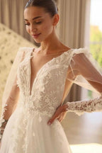 Hermoso vestido de novia largo de tul con encaje, escote en V y mangas largas.