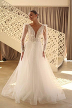Hermoso vestido de novia largo de tul con encaje, escote en V y mangas largas.