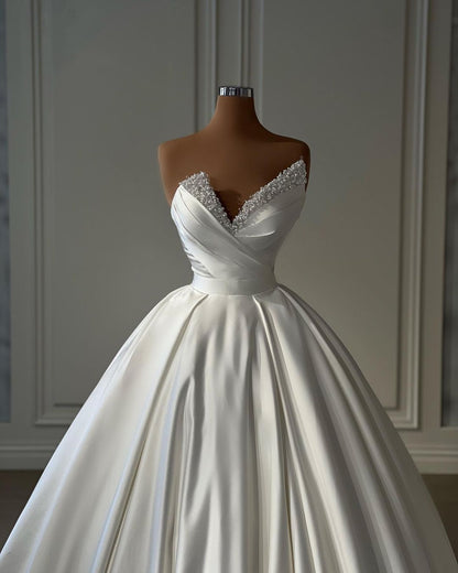 Wunderschönes langes elfenbeinfarbenes A-Linien-Prinzessinnen-Brautkleid aus Satin mit Perlen