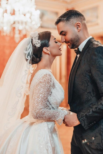 Encantador vestido de novia largo de corte A con encaje, lentejuelas y cuentas, mangas largas y cola desmontable.