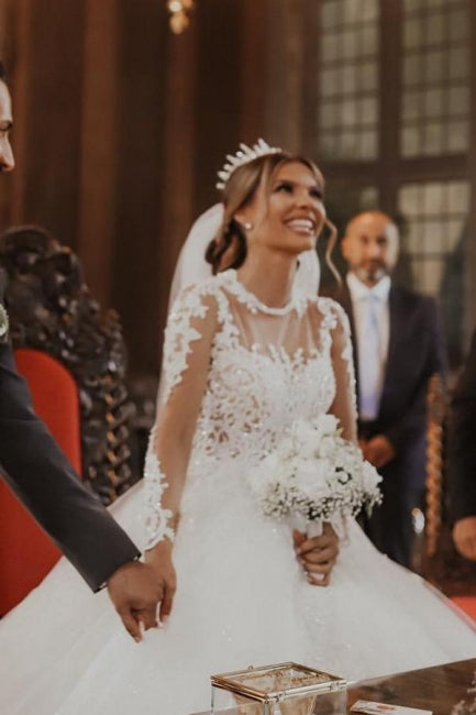 Elegante vestido de novia blanco largo de tul con encaje y mangas largas.