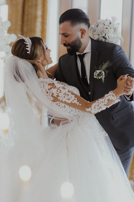 Elegante vestido de novia blanco largo de tul con encaje y mangas largas.