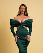 Vestido de fiesta largo de diseño verde oscuro con escote sirena, hombros descubiertos, pedrería y mangas largas