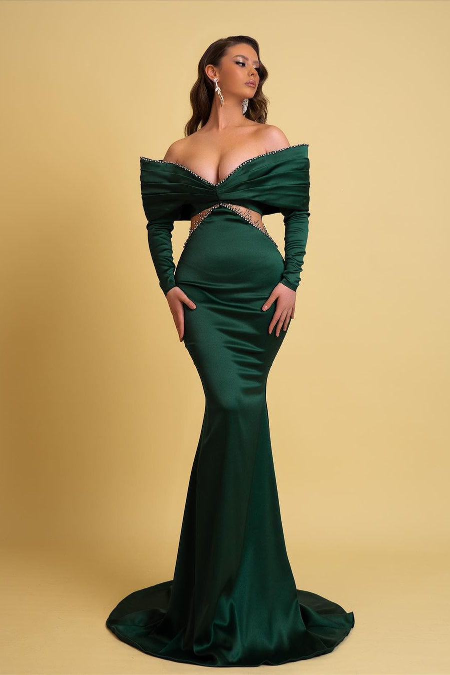 Vestido de fiesta largo de diseño verde oscuro con escote sirena, hombros descubiertos, pedrería y mangas largas