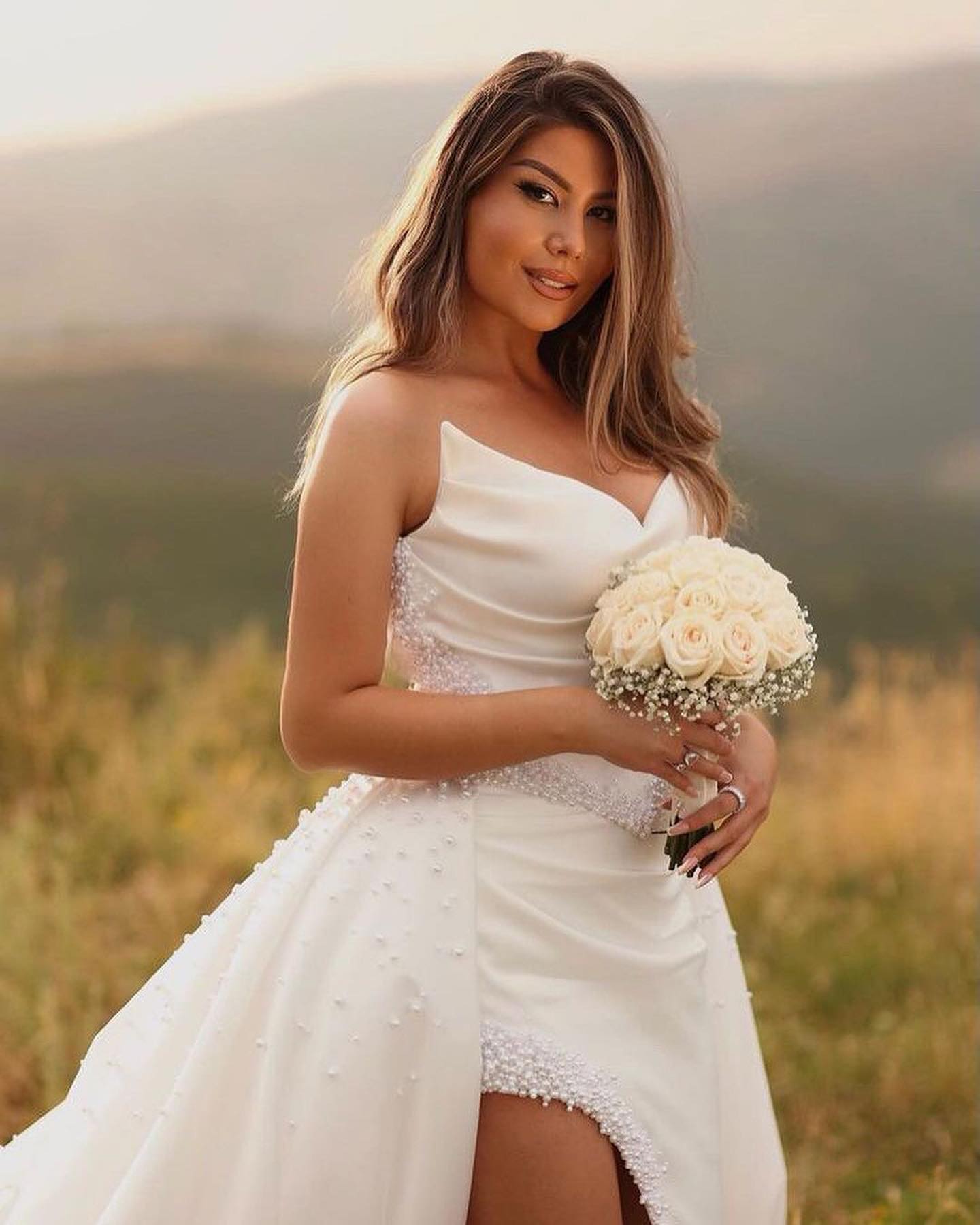 Vestido de novia largo blanco de diseñador, corte A, sin mangas, escote en V y abertura alta de satén.