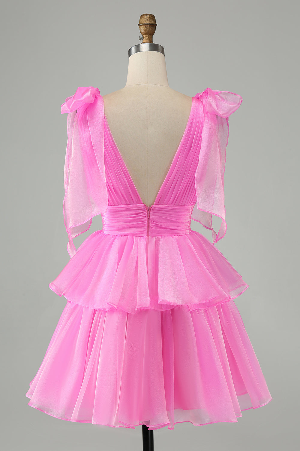 Hermoso vestido de fiesta corto rosa intenso con escote en V, espalda descubierta, plisado y capas