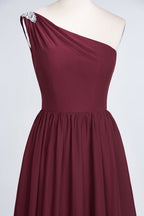 Vestido de dama de honor de corte A, un hombro, sin mangas, con volantes y cuentas, largo hasta el suelo.