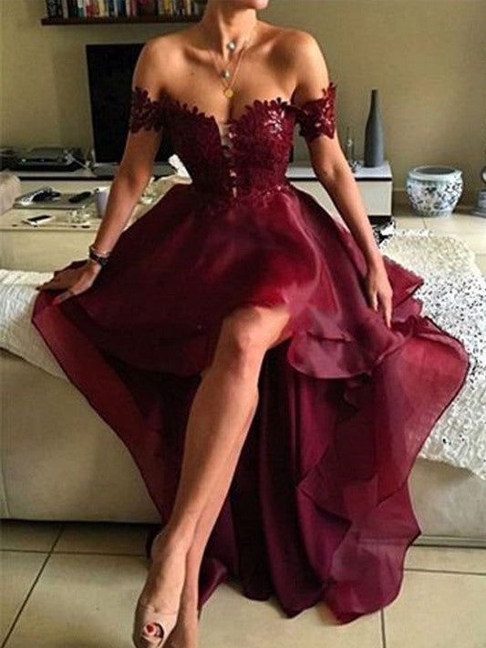 Elegante vestido de fiesta de organza con apliques asimétricos, sin mangas y hombros descubiertos.