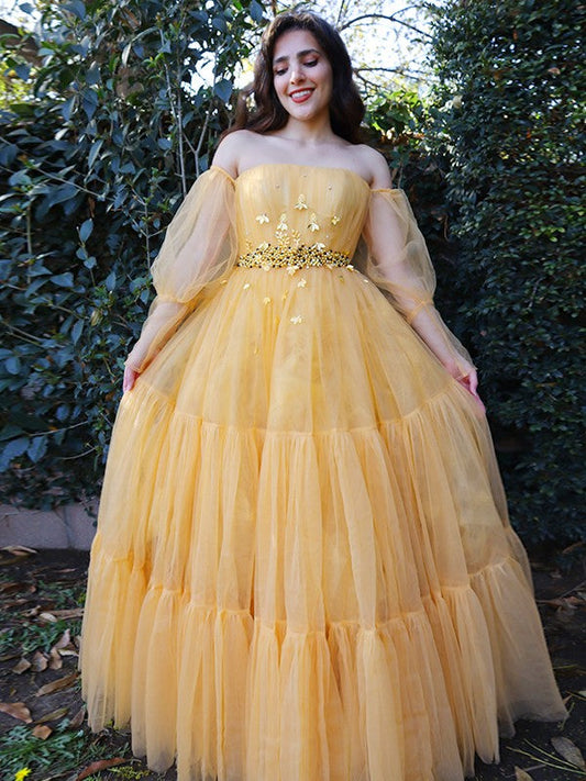 Elegante vestido de fiesta de tul con cuentas, hombros descubiertos, mangas largas y largo hasta el suelo.