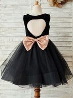 Vestido de terciopelo negro hasta la rodilla con lazo de lentejuelas en la espalda en forma de corazón