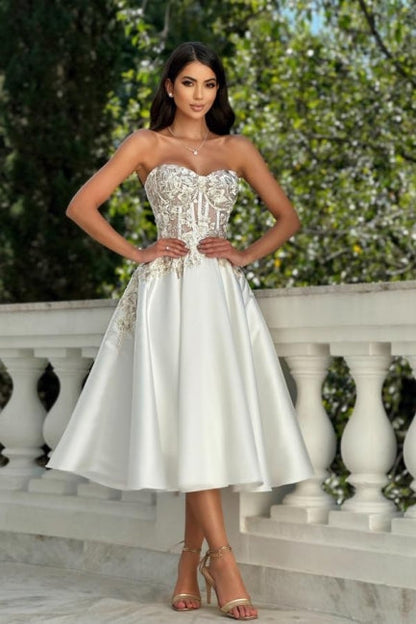Impresionante vestido de fiesta color marfil sin mangas con escote corazón, encaje satinado y apliques.