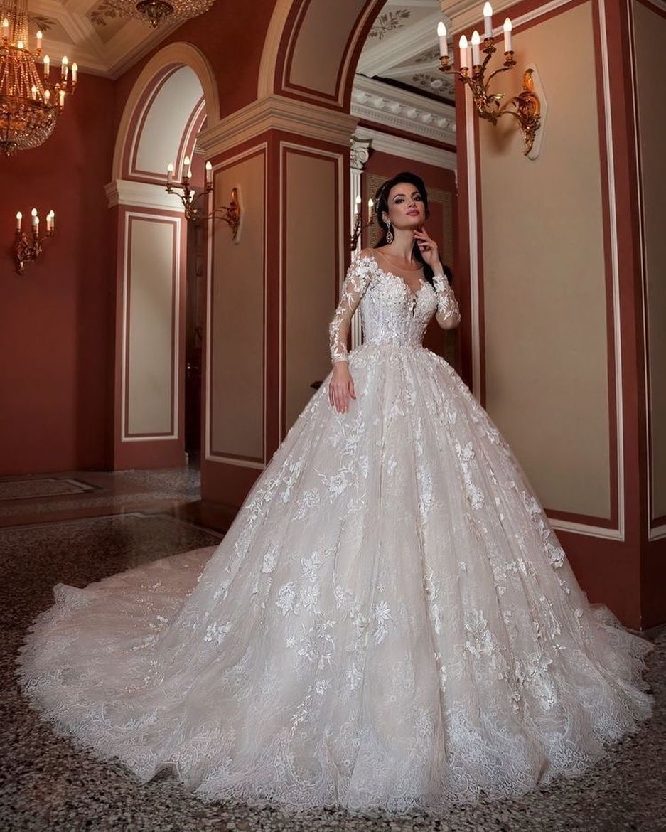 Atractivo vestido de novia largo de corte A con escote barco, apliques de cuentas y cola de encaje con mangas