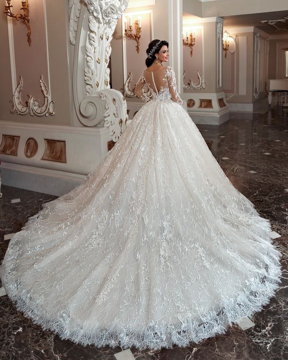 Atractivo vestido de novia largo de corte A con escote barco, apliques de cuentas y cola de encaje con mangas