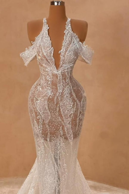 Atractivo vestido de fiesta largo color marfil con cuello halter, hombros descubiertos, corte sirena, abertura frontal y encaje