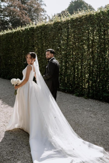Hermosos vestidos de novia blancos sin mangas, de satén, con hombros descubiertos y abertura frontal.