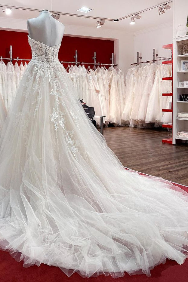 Hermoso vestido de novia largo de tul color marfil sin tirantes, corte A y apliques de encaje.