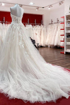 Hermoso vestido de novia largo de tul color marfil sin tirantes, corte A y apliques de encaje.