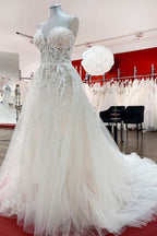Hermoso vestido de novia largo de tul color marfil sin tirantes, corte A y apliques de encaje.