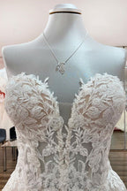 Hermoso vestido de novia largo de tul color marfil sin tirantes, corte A y apliques de encaje.