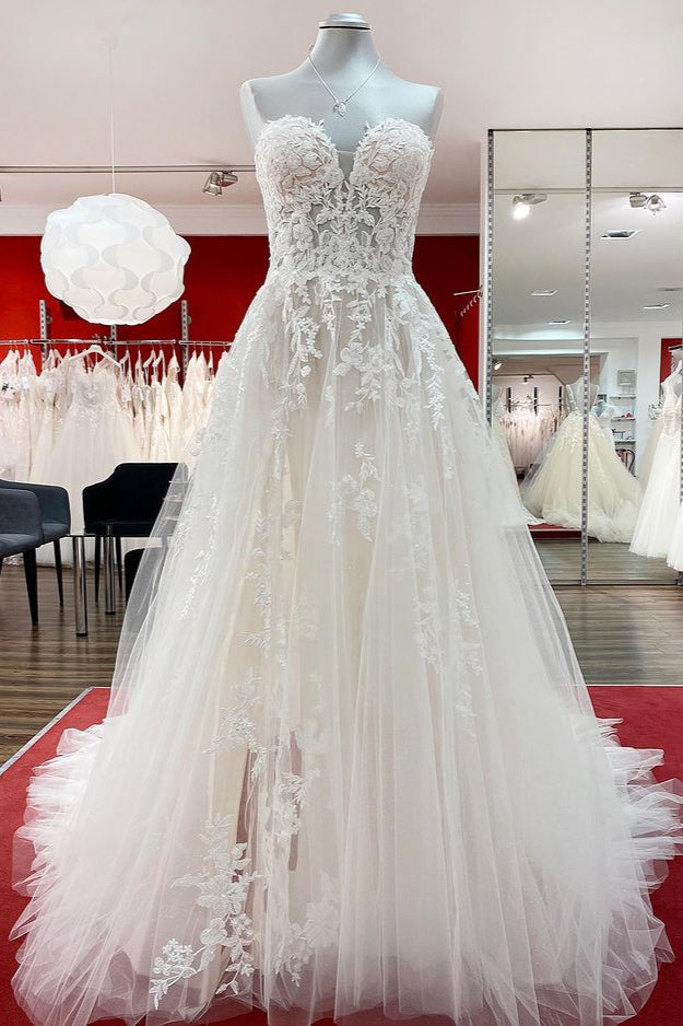 Hermoso vestido de novia largo de tul color marfil sin tirantes, corte A y apliques de encaje.