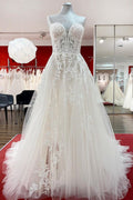 Hermoso vestido de novia largo de tul color marfil sin tirantes, corte A y apliques de encaje.