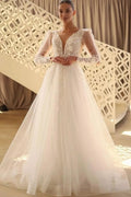 Hermoso vestido de novia largo de tul con encaje, escote en V y mangas largas.