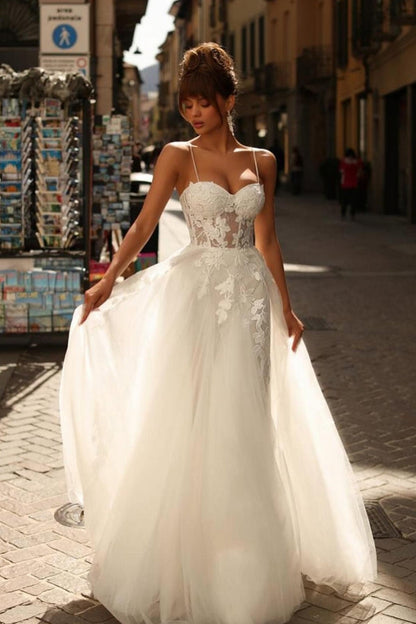 Wunderschönes langes elfenbeinfarbenes A-Linien-Brautkleid mit Spaghettiträgern und Spitze