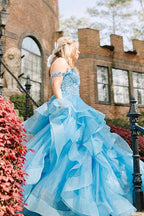 Vestidos de fiesta largos de tul con volantes y hombros descubiertos en azul con apliques