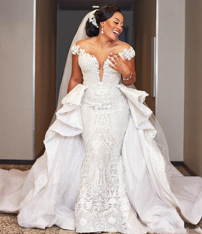 Vestido de novia largo estilo sirena con mangas cortas y sobrefalda con volantes